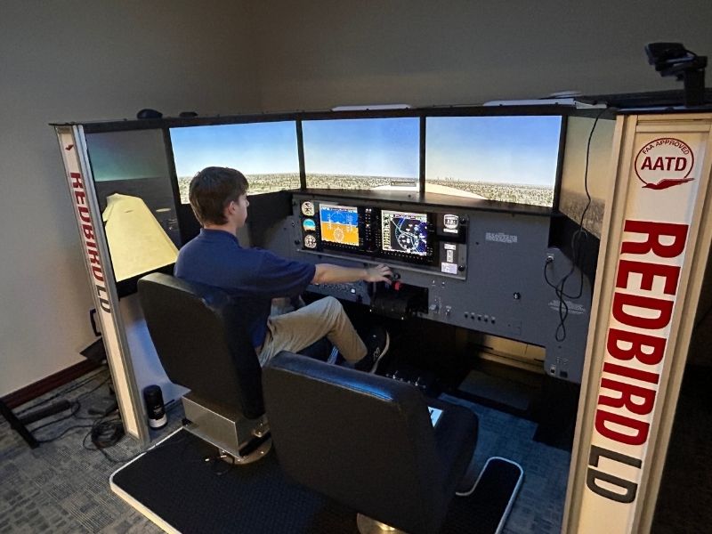 Rising Aviation student flying a redbird flight simulator